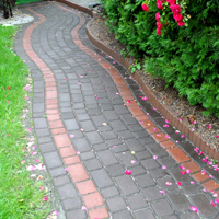 Chodnik przy domu wykonany w kształcie łuku w dwóch kolorach