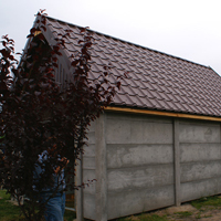 Mały garaż z płyt betonowych z 2-spadowym brązowym dachem